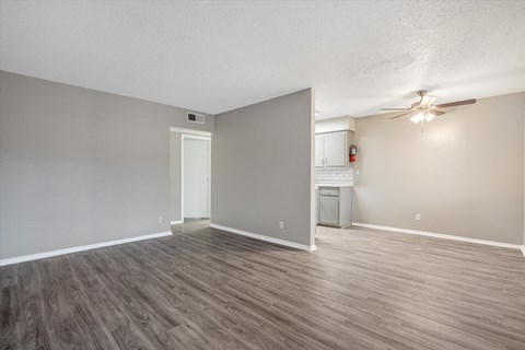 the living room and kitchen of an empty apartment